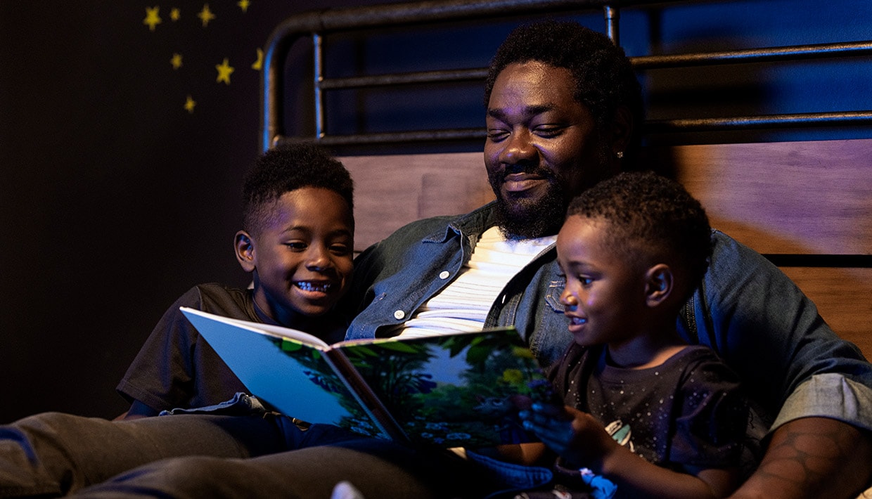 Father reading to sons in bed